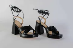 Sandalias de cuero negro con plataforma y tacón cuadrado. Presentan tiras finas que se atan al tobillo. Marca Maria Victoria.