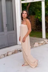 Pantalón de corte amplio y tiro medio, confeccionado en tela crepe color beige, con diseño fluido y holgado.