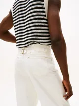 Pantalón jean blanco de corte amplio y pierna recta, con cintura ajustable en la parte trasera. Presenta cierre de cremallera con botón, dos bolsillos delanteros de parche y dos bolsillos traseros ribeteados. Detalles distintivos de la colección APXGP.