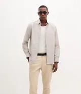Pantalón slim de sarga color beige para hombre, con cintura con trabillas, cierre tradicional y bolsillos laterales y traseros.