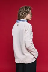 Sweater de tejido de punto negro con tramas de ochos en las mangas y laterales, cuello redondo a la base y mangas largas.