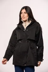 Campera tipo trench de nylon color negro, con capucha, cierre frontal y cordón ajustable en la cintura.