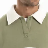 Buzo de estilo rugby con cuello camisero en contraste color crema, confeccionado en algodón y poliéster. Presenta una franja horizontal azul en el pecho con el logo de la marca estampado y diseño de manga larga.