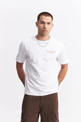 Remera de manga corta color verde menta, con escote redondo y fit regular. Presenta un estampado en la espalda con la frase "NO RULES! BREAK THE RULES" y un diseño abstracto en tonos azules y blancos.