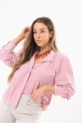 Camisa de manga larga con diseño a rayas rojas y blancas, cuello camisero y cierre frontal con solapa.