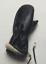 Guantes manoplas de cuero color negro, con diseño fruncido en la muñeca, detalle de pelo sintético en el borde y tira ajustable con herrajes metálicos dorados.