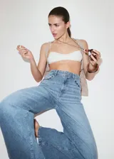 Jeans de denim celestes de tiro medio, diseño de corte recto y amplio con detalles de tachuelas en los bolsillos delanteros.