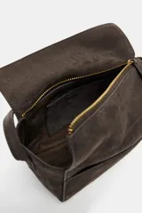 Mini bolso de mano confeccionado en piel, con asa corta, cierre de cremallera y solapa superior. Cuenta con bolsillos exteriores en la parte delantera y trasera, y un bolsillo interior con cierre.