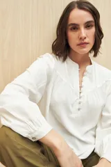 Camisa verde claro de viscosa suave, con cuello mao y botonadura parcial al frente. El detalle de frunces en los hombros y los puños abotonados le suman delicadeza y estilo.