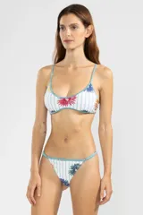 Bombacha de bikini de cobertura mínima con estampado floral y rayas verticales, cuenta con deslizadores laterales ajustables y ribetes en color turquesa.