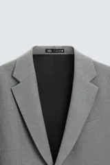 Blazer azul marino de corte recto, confeccionada en tejido con viscosa. Tiene cuello con solapas de muesca, manga larga con puño abotonado, bolsillo de vivo en el pecho y bolsillos de parche en la cadera. El bajo tiene aberturas en la espalda y el cierre es con botonadura frontal.