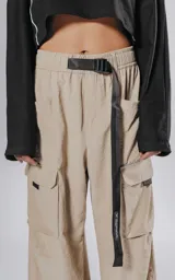 Pantalon cargo color vison de silueta oversize y pierna recta ancha. Cuenta con cintura elastizada, cinturón integrado con hebilla de seguridad, múltiples bolsillos laterales con solapa y detalles reflectivos.