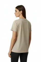 Remera de algodón manga corta con cuello redondo y corte al cuerpo. Presenta un estampado central con diseño artístico y detalles de studs aplicados.