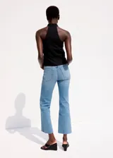 Jeans de denim celestes de tiro medio, con corte recto y terminación deshilachada en los tobillos.