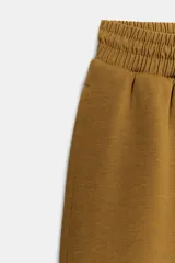 Pantalón de tiro medio y pierna ancha, confeccionado en hilatura con mezcla de algodón. Cuenta con cintura elástica con cordón de ajuste, bolsillos laterales ocultos y bajo abullonado con pliegues frontales.