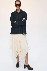 Chaqueta de denim azul oscuro con cuello solapa, manga larga y cierre frontal mediante alamares decorativos de estilo oriental.