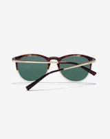 Lentes de sol Hawkers unisex, modelo Ollie. Marco de carey con borde inferior transparente, lentes verdes y patillas doradas.