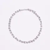 Collar tipo gargantilla plateado con eslabones rectangulares unidos por pequeñas esferas metálicas. Posee un cierre de mosquetón con cadena de ajuste.