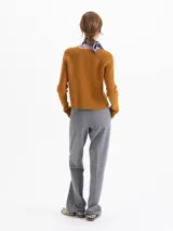 Cardigan de punto acanalado en color azul marino, con ajuste al cuerpo, mangas largas raglán y cierre frontal con botones dorados.