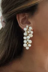 Aros colgantes de diseño artesanal, compuestos por una estructura de alambre dorado que sostiene un racimo de perlas cultivadas y discos de nácar de distintos tamaños.