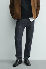 Jeans de corte slim fit en color azul oscuro, con diseño de cinco bolsillos, cierre frontal con cremallera y botón, y tejido ligeramente elástico.