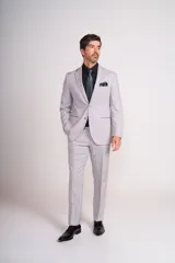 Ambo de ceremonia color gris claro, compuesto por saco de corte entallado con cierre de un botón y pantalón de vestir a juego. El saco presenta solapas clásicas y bolsillos con solapa.