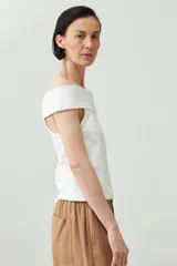 Remera de color marrón con escote bardot, diseño ajustado al cuerpo y mangas cortas.