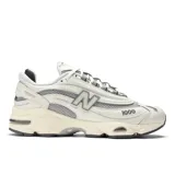 Championes New Balance modelo 1000 de hombre, color crema con detalles en gris y logo "N" en los laterales.