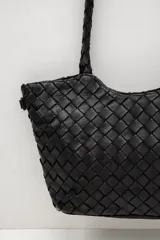 Cartera de cuero marrón con diseño trenzado y asas de hombro trenzadas.