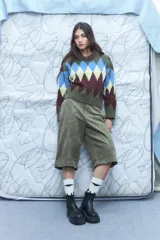 Sweater de punto grueso con rombos en tonos verde, azul, marrón y amarillo. Tiene cuello en V y mangas largas.