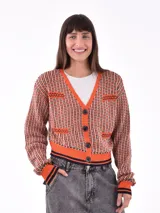 Saco negro de tejido de punto, con cuello en V, cierre frontal de botones y bolsillos delanteros. Presenta puños y ruedo con terminación acanalada en color negro y naranja.