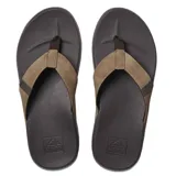 Sandalias tipo ojota Reef, con base de goma texturizada color marrón oscuro y tiras de tela en tono marrón claro.