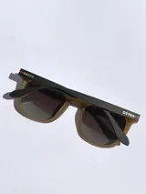 Lentes de sol marca Osten modelo Tokyo, con armazón de acetato en tono verde oliva mate y cristales oscuros polarizados. Presentan un diseño de marco completo con detalle de logo grabado en la patilla.