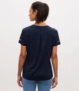 Remera deportiva de manga corta con cuello redondo, confeccionada en tejido texturizado con detalle reflectante y pliegue en la espalda.