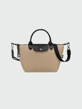 Bolso de mano tipo tote de la línea Le Pliage Energy de Longchamp, en color beige con detalles en negro. Cuenta con asas cortas, solapa frontal con cierre de botón a presión y correa lateral con cordón ajustable.