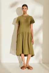 Vestido midi color crudo de manga corta, con corte en la cintura y falda holgada con volados y detalle de pequeño bordado de hongo en el pecho.