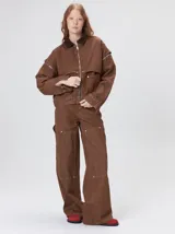 Campera de denim a rayas verticales con cuello de pana en color bordó. Presenta cierre frontal, mangas desmontables con cierre en los hombros, canesú en el pecho y bolsillos de parche cuadrados.