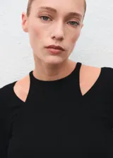 Camiseta de canalé color negro, de manga larga y diseño entallado con cuello halter y aberturas en los hombros.