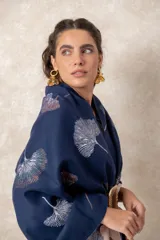 Pashmina reversible de textura suave y caída fluida, con diseño estampado de hojas de ginkgo biloba. Presenta un lado con fondo oscuro y otro con fondo claro, finalizando en ambos extremos con flecos cortos deshilachados.