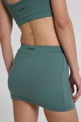 Minifalda deportiva color verde azulado, confeccionada en tejido Activelu con compresión media, cintura alta y protección UV50+.