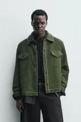 Sobrecamisa de hombre relaxed fit color verde oscuro, confeccionada en tejido de textura efecto toalla. Cuenta con cuello solapa, manga larga con puño abotonado, bolsillos de parche con solapa en el pecho, pespuntes a contraste y cierre frontal con botones.
