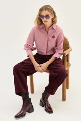 Bota tipo chelsea de cuero charolado color bordó, con caña media, elásticos laterales negros y taco cuadrado bajo.