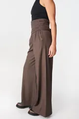 Pantalón de tiro alto con corte holgado y pierna ancha. Presenta bolsillos laterales ocultos en la costura y una faja desmontable ajustable en la cintura.