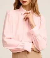 Camisa celeste de crepé con cuello inglés, manga larga abullonada y abotonadura frontal.