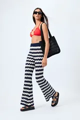 Pantalón tejido con motivo zigzag en blanco y negro, de corte flare y cintura elastizada.