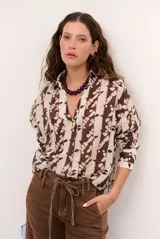 Blusa estampada en tonos marrón y crudo, de corte holgado, con cuello camisero, escote en V y mangas largas.