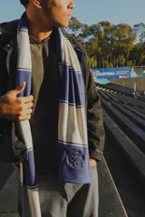 Bufanda larga de tejido de punto con rayas horizontales anchas en color blanco y azul.