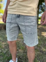 Bermuda de jean gris claro con efecto acid wash, bolsillos delanteros aplicados y costuras destacadas.