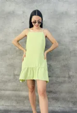 Vestido corto verde lima con textura plumeti, corte suelto, breteles finos y volado en el ruedo.