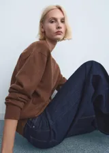 Jeans de denim azul oscuro con diseño de tiro medio y corte ancho en las piernas, con bolsillos delanteros y traseros.